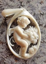 天使のペンダントトップ　アイボリー　アンティーク 　花束を抱えるエンジェル